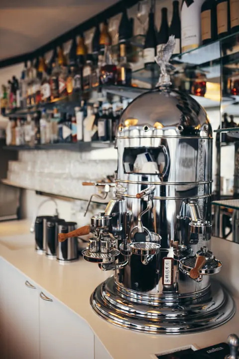 Barbereich mit Kaffeemaschine und Flaschenregal