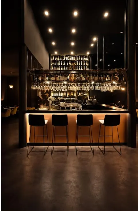 Bar mit Barhockern und Lichtdecke